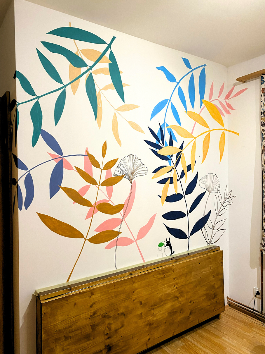 Photo of wall painted with bright coloured leaves as a decoration of a room