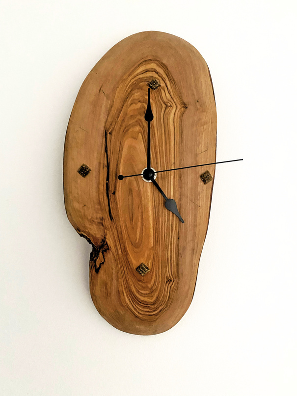 Photo of a handmade wooden wall clock used for decoration of a wall of apartment