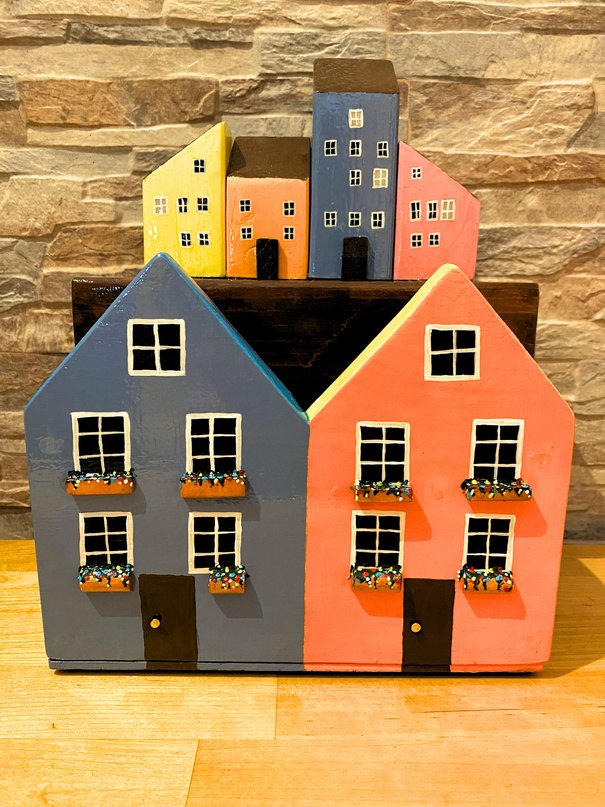 Photo of brightly coloured decoration wooden box made in the shape of houses with windows and balconies